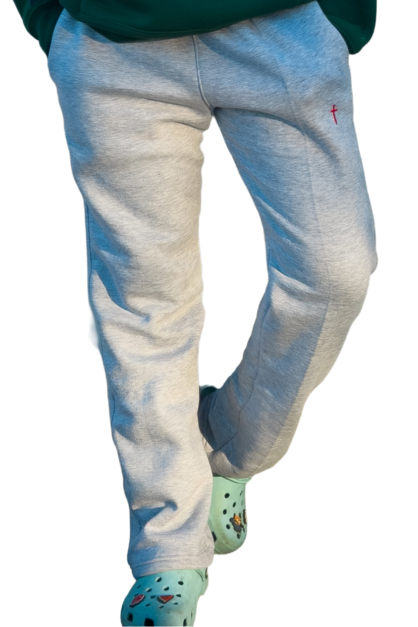 Person wearing a green hoodie and light blue jeans on a white background